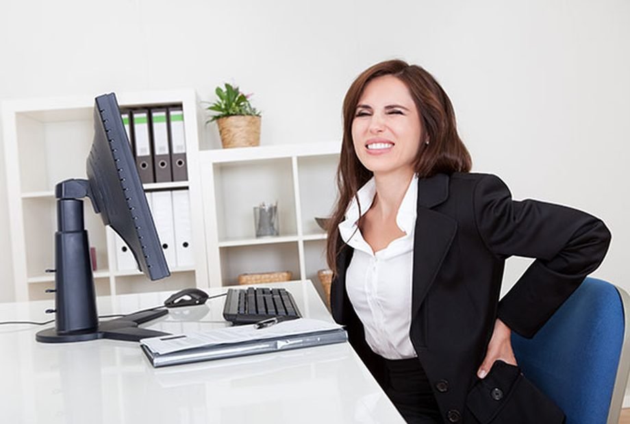 Mujer con dolor lumbar en la oficina